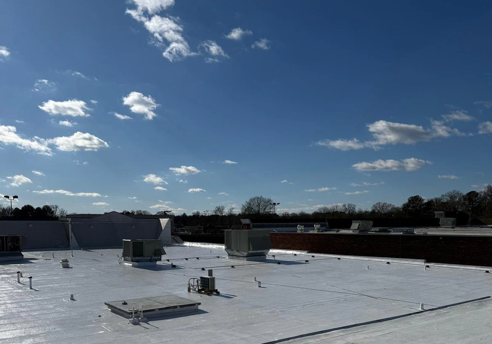 Commercial flat roof waterproofed with white coating and rooftop HVAC units