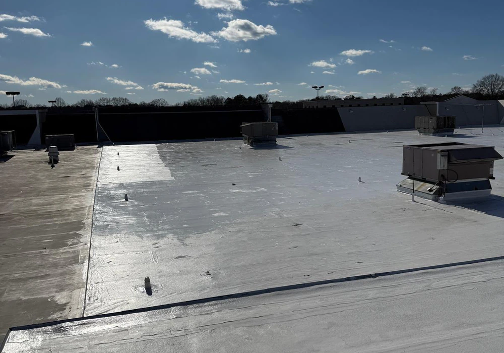Commercial flat roof during white waterproof coating application